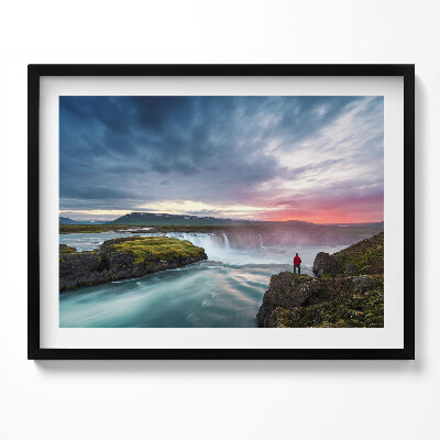 Kép keretben Vízesés naplementében sziklán álló ember