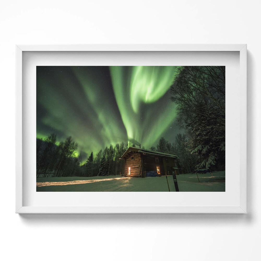 Kép keretben Északi fény egy faház felett